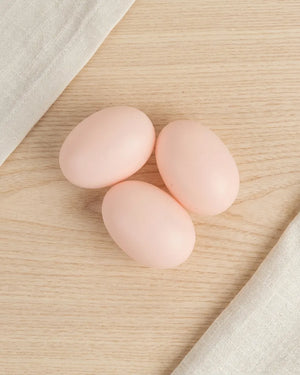 Three pale pink plastic eggs for egg-laying chicken toy