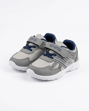 Grey kids sports sneakers worn on feet with padded collar and white outsole