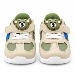 Alternate side view of a green and beige kids’ sneaker with blue accent stripe and white sole.