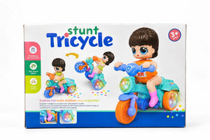 Side view of doll rider on turquoise stunt tricycle with pink boots and blue wheels