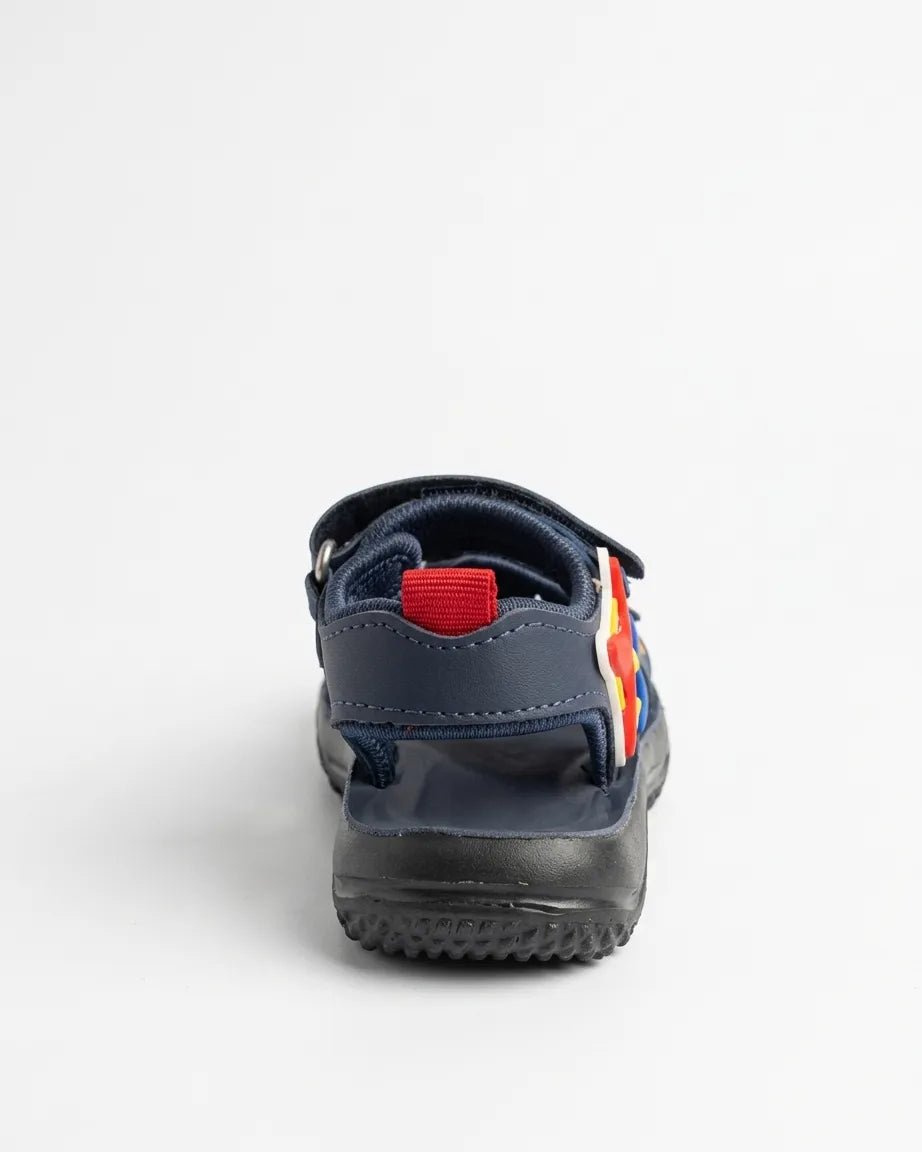 Child wearing navy open-toe sandals with red starfish decorations