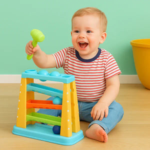 Baby playing with the hammering toy, holding the green mallet over the frame.