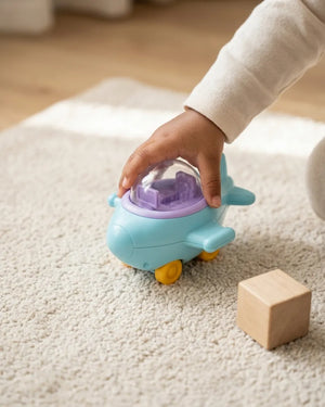 Sky-blue toy airplane with open dome and purple interior, rolling on wheels