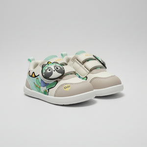 A pair of toddler's lace-up sneakers with a cartoon dinosaur and panda design, displayed on a store counter.