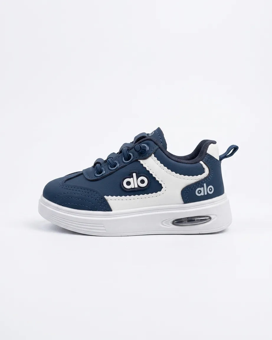 Blue Alo kids sneakers worn with light trousers, showing side detail and white soles