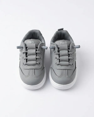 Pair of beige Alo kids sneakers from the front showing laces and rounded toes