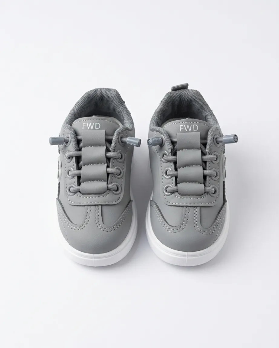 Pair of beige Alo kids sneakers from the front showing laces and rounded toes