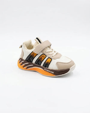 Side view of beige kids sneaker with strap, decorative laces and orange chunky sole