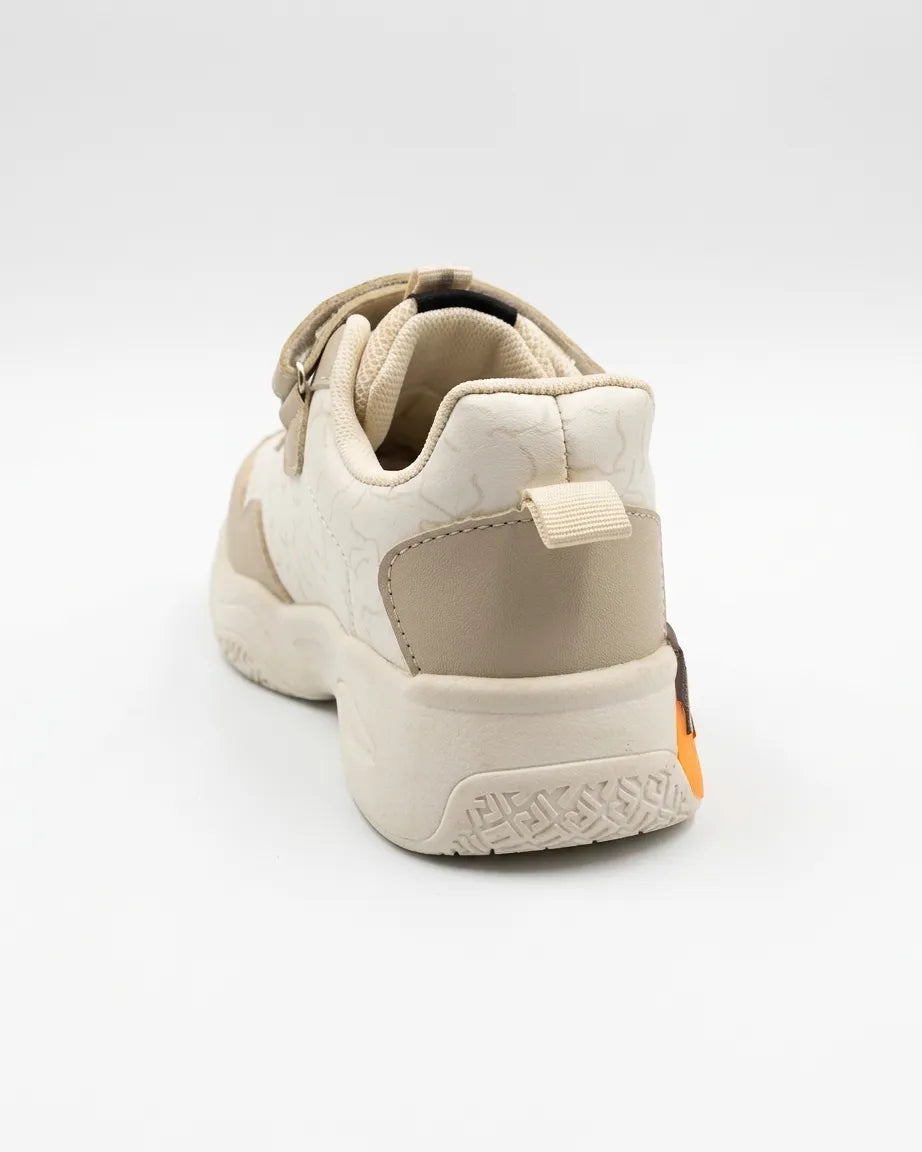 Child wearing navy and white kids strap sneakers with orange accents