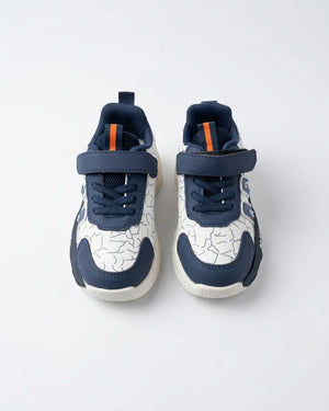 Beige kids strap sneaker in profile showing brown and orange side detail