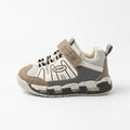 Side view of beige, grey and white kids sport sneaker with strap and chunky segmented sole
