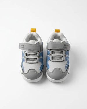 Pair of grey and blue kids sneakers with Velcro strap and elastic laces, top view