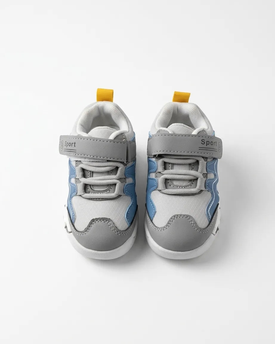 Pair of grey and blue kids sneakers with Velcro strap and elastic laces, top view