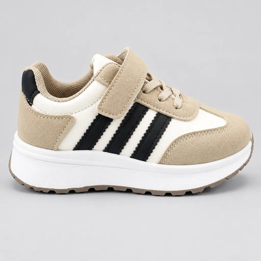 Side view of PrimeBee kids sneaker showing beige, white and black panels and chunky sole