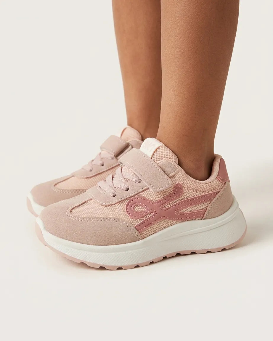 Pink girls' sneakers with straps and chunky white soles styled on foot