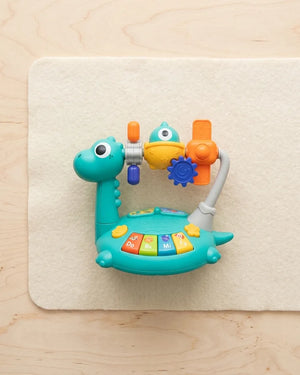 Kids dinosaur cartoon hand-crank piano toy with teal keyboard and crank handle