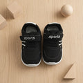 Beige kids sports sneakers with laces and hook-and-loop strap worn on feet