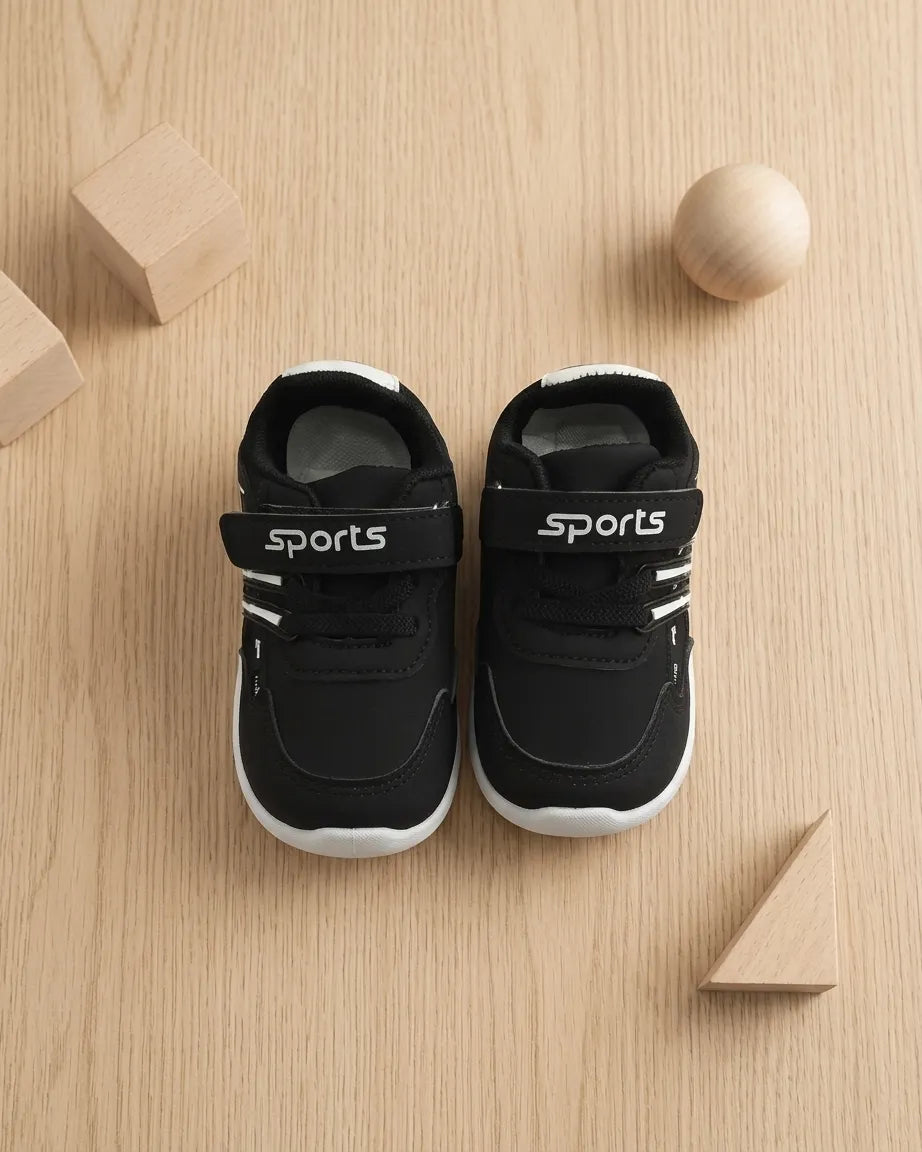 Beige kids sports sneakers with laces and hook-and-loop strap worn on feet