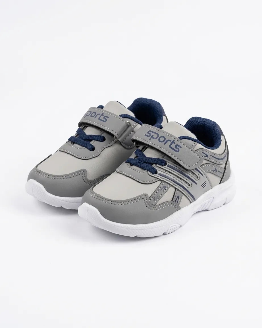 Grey kids sports sneakers worn on feet with padded collar and white outsole