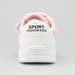 Underside of a white kids’ sneaker showing the patterned outsole tread.