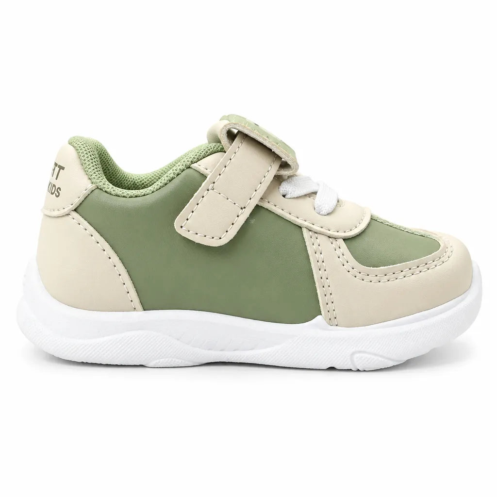 Back view of a green and beige kids’ sneaker with a mesh-textured collar.