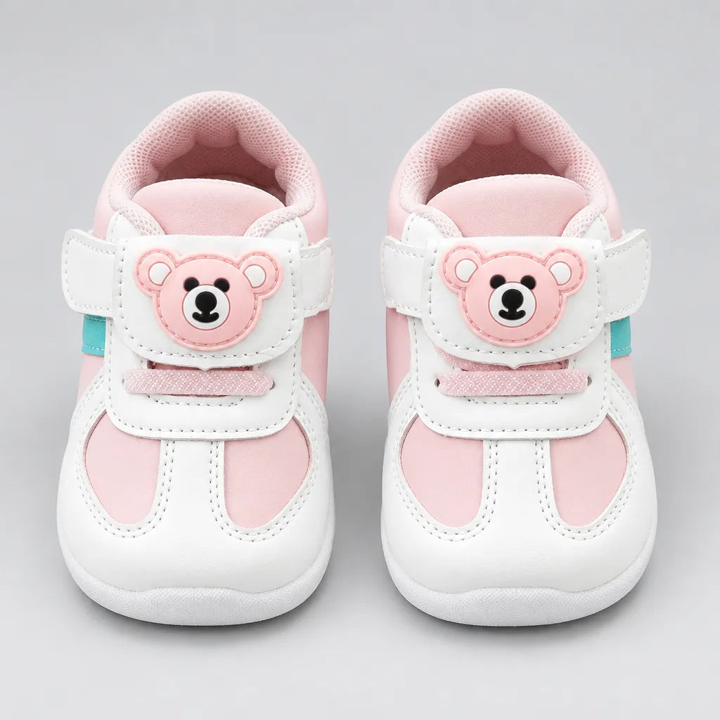 Back view of a pink and white kids’ sneaker with a mesh-textured collar.