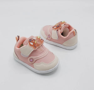 Light pink kids' sneakers with bear charm straps, white sole, orange-tan lace tabs