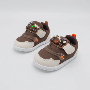 Angled view of brown Glow Bear kids shoe with bear-detail strap and white sole