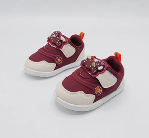 Deep burgundy kids' sneakers with bear patch, white sole, orange lace loops