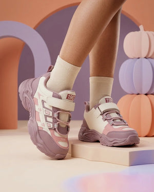 Blue and cream kids chunky sneakers worn by a child, side view of sculpted sole