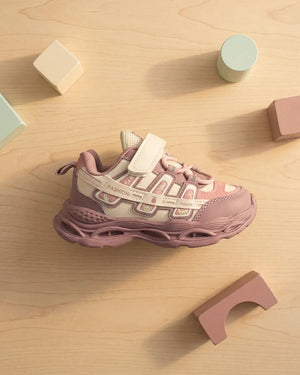 Maroon and pink kids chunky sneakers worn by a child on a display platform