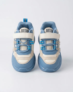 Maroon and pink kids chunky sneaker, side view on a wooden background