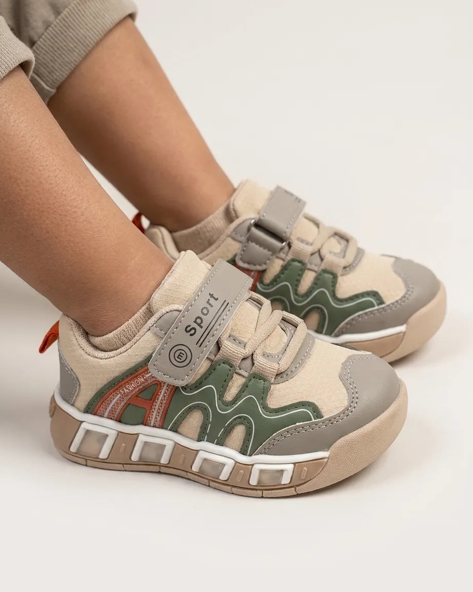 Child wearing beige and olive strap sneakers with chunky textured outsole