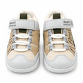 Side view of a beige and olive green kids sport sneaker with grey accents, hook-and-loop strap, lace-style detailing and chunky segmented sole