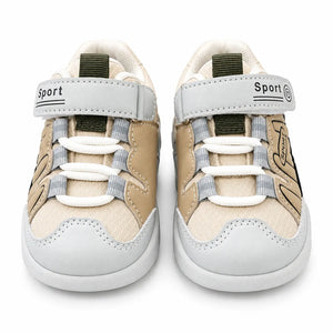 Side view of a beige and olive green kids sport sneaker with grey accents, hook-and-loop strap, lace-style detailing and chunky segmented sole