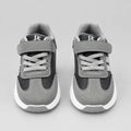 Rear view of grey and black kids’ sneaker showing the grey collar and white sole