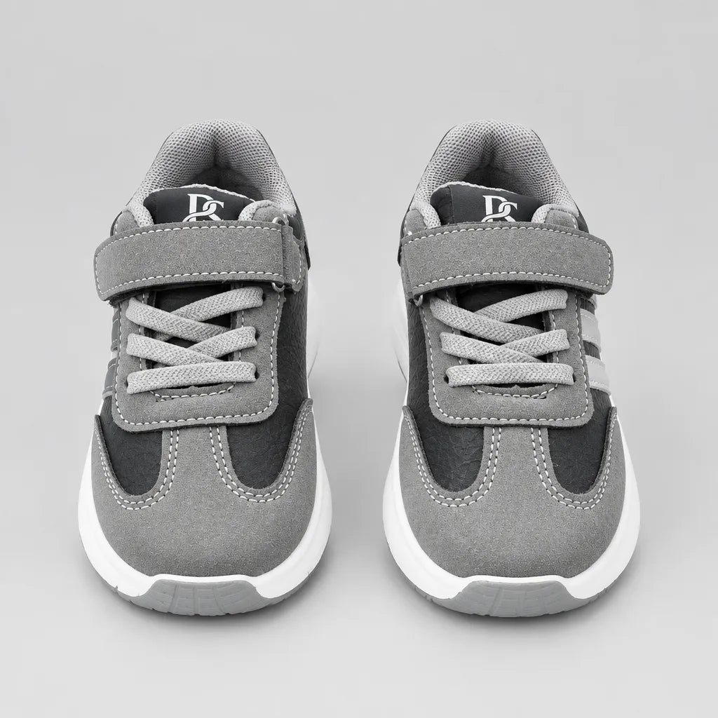 Rear view of grey and black kids’ sneaker showing the grey collar and white sole