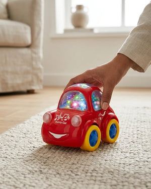 Red flashing bump car toy with colorful window lights held by a hand on carpet