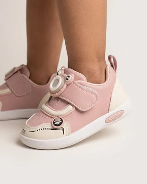Side view of pink kids sneakers with easy fastening strap